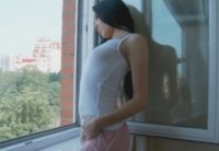 Мечтающая о сексе девушка перед окном мастурбирует и кончает стоя
